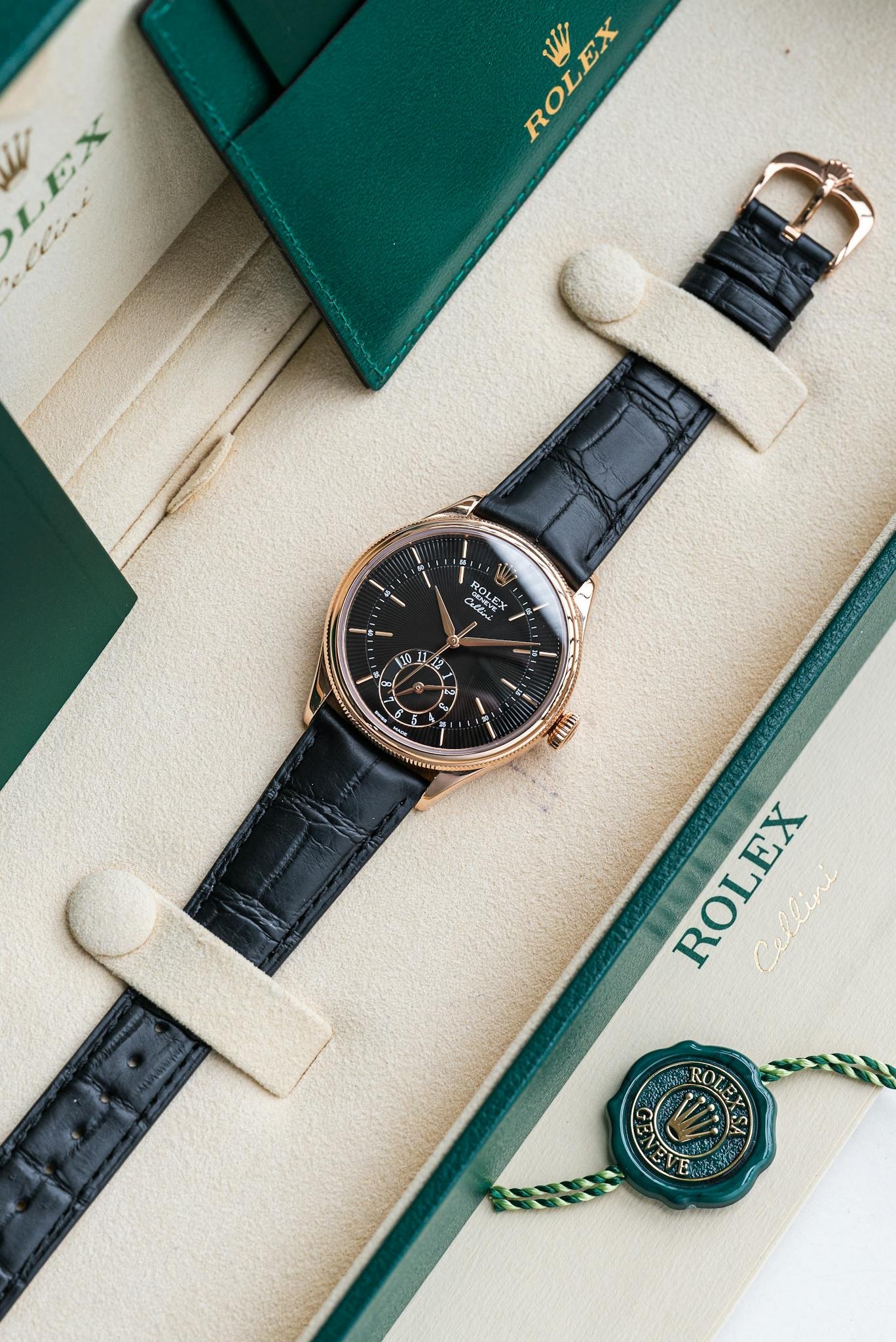 Elegant Rolex watch displayed in a luxury box with green accents and leather strap.